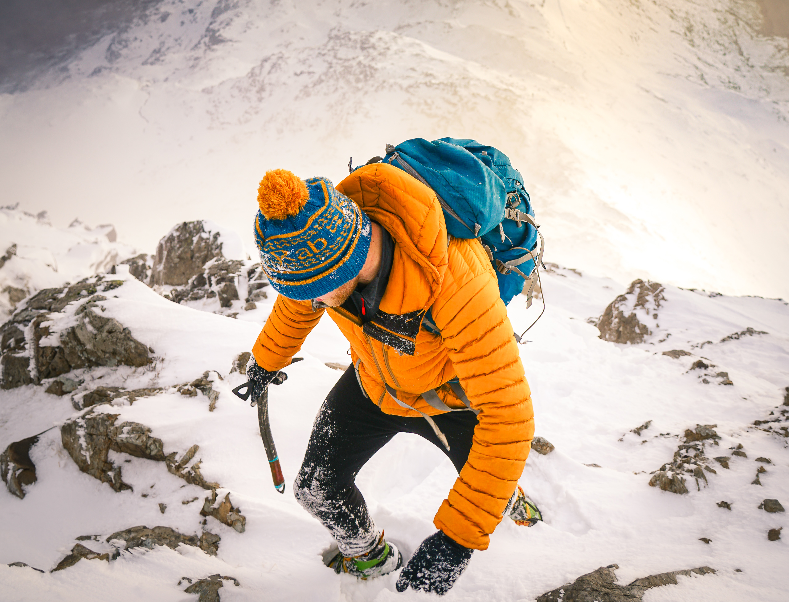 A product adventure shot of a climber on crib goch, snowdonia, wearing RAB brand clothing